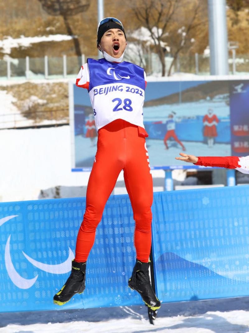 Chenyang Wang of China reacts after winning the gold  as compatriot Jiayun Cai looks on following the Men's Middle Distance Free Technique Standing at the Beijing 2022 Paralympic Winter Games at Zhangjiakou National Biathlon Centre. 